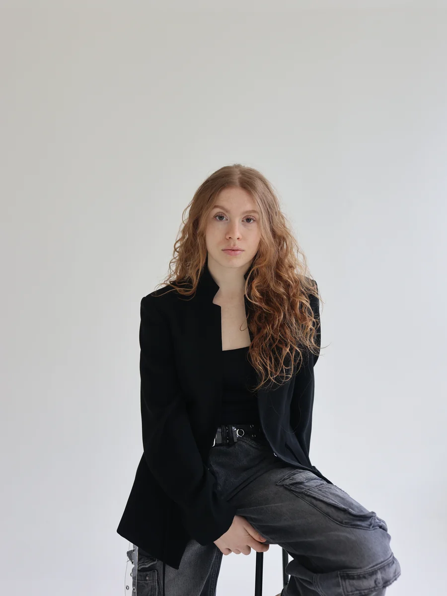 Tara seated in a black blazer