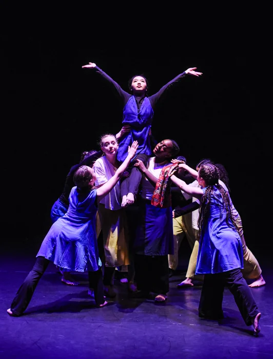 An ensemble performing together on stage
