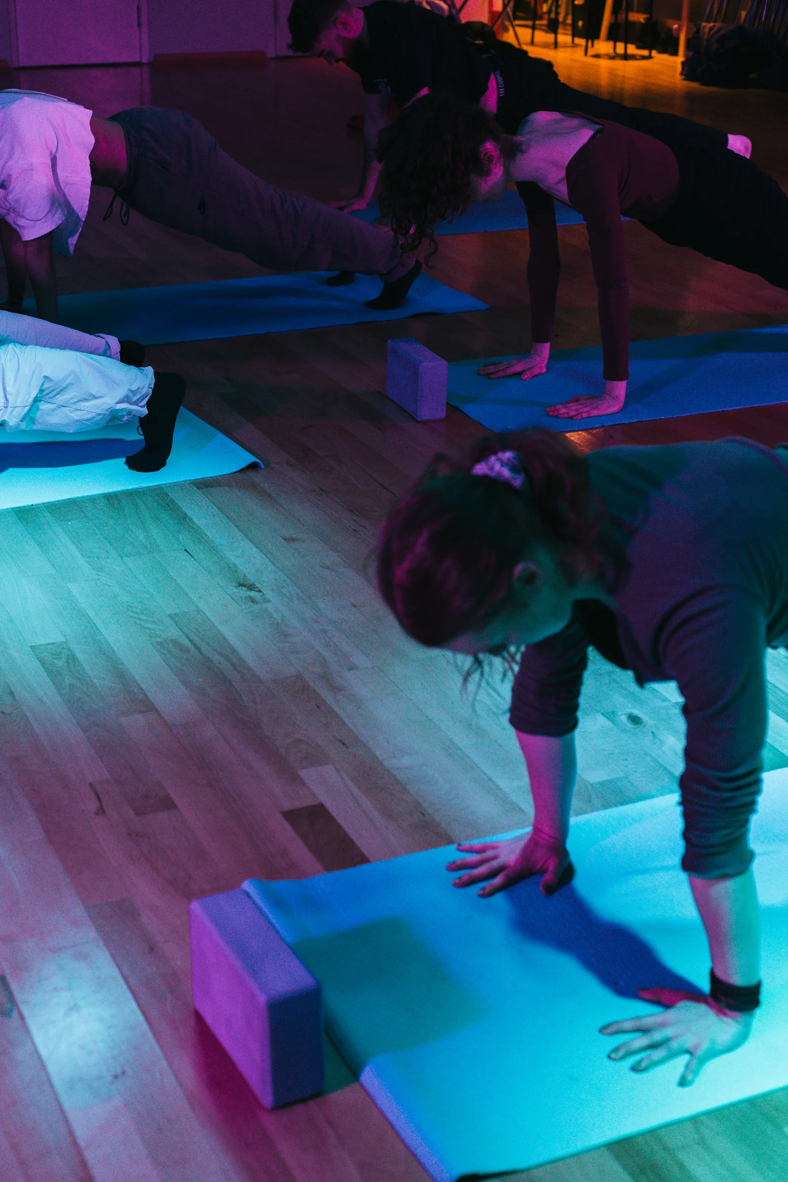 Participants practising on their hands and feet on studio mats