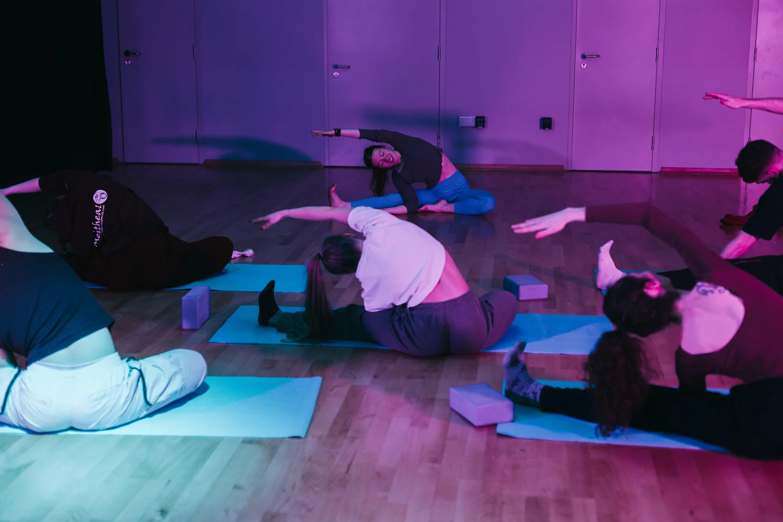 A group stretching together on mats in the studio