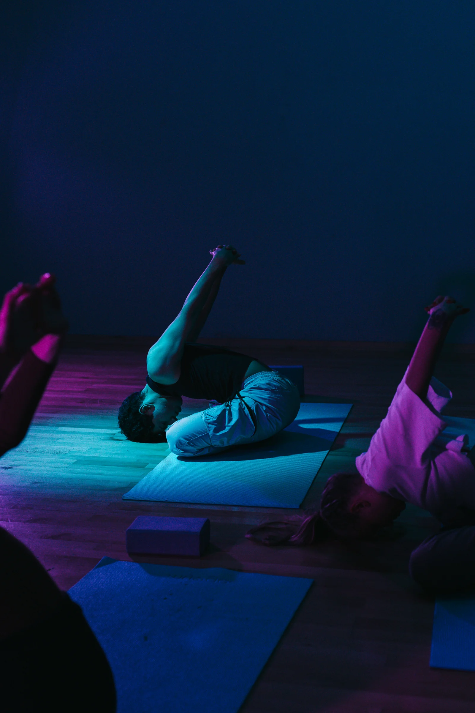 A participant raising one leg during floor-based Pilates