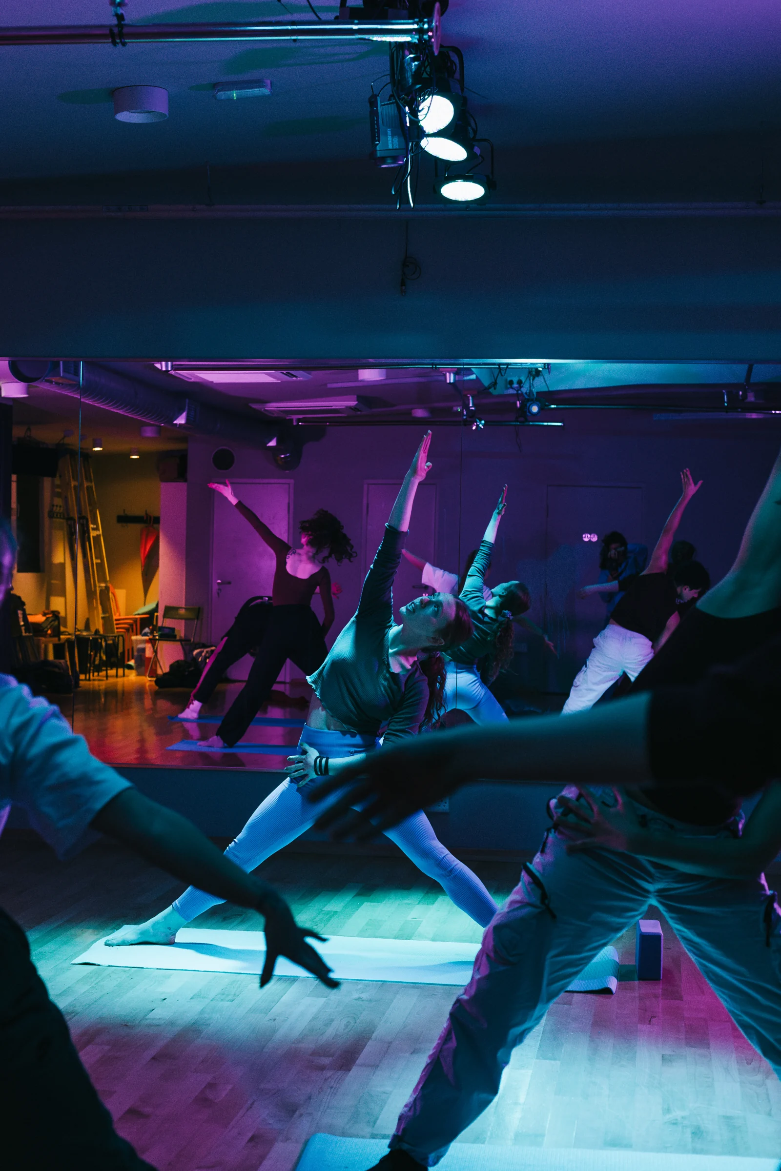A group reaching upward during a shared Pilates session